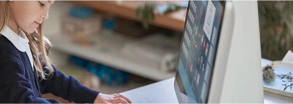 Young child using a computer in a modern home office setting.